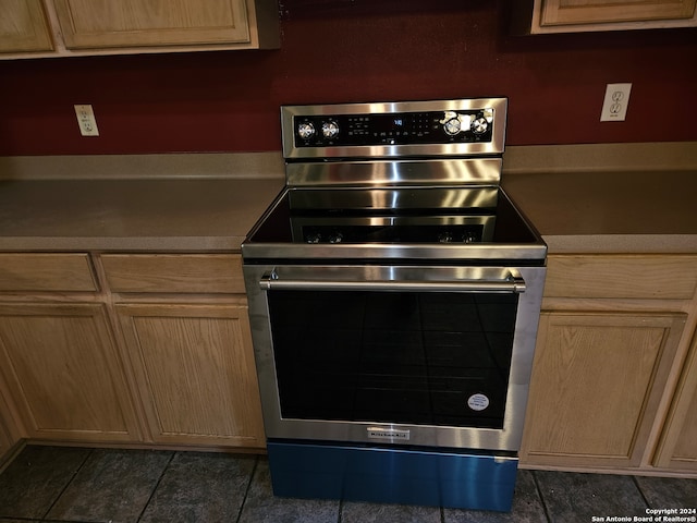 kitchen with electric range and dark tile patterned flooring