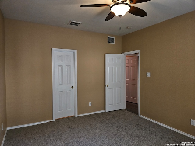 unfurnished bedroom with dark carpet and ceiling fan