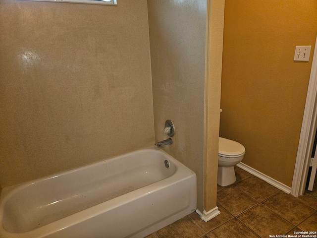 bathroom featuring toilet, a tub to relax in, and tile patterned flooring