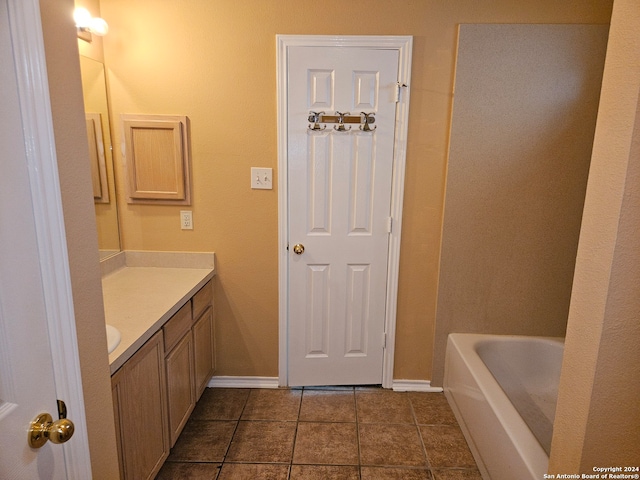 bathroom featuring vanity, a tub, and tile patterned floors