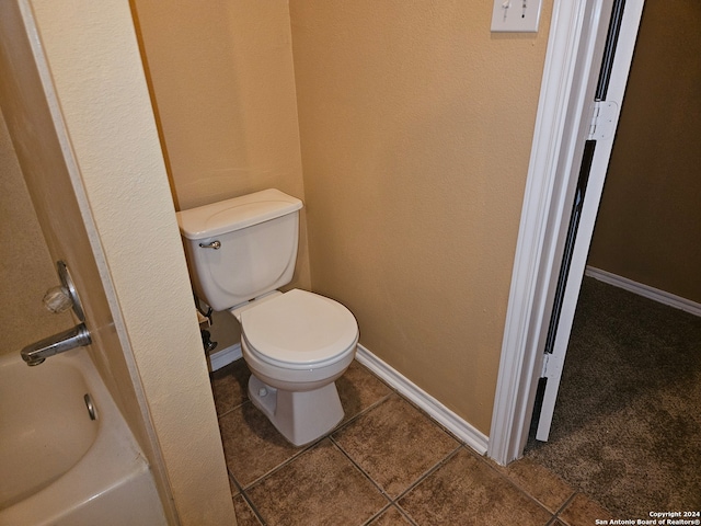 bathroom with a bathtub, toilet, and tile patterned floors