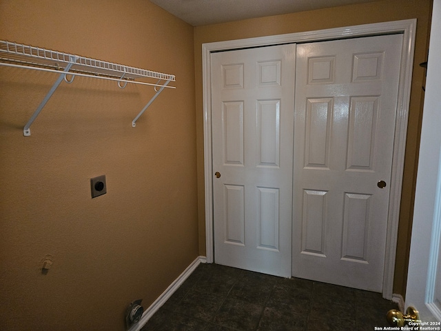 washroom featuring dark tile patterned flooring and electric dryer hookup