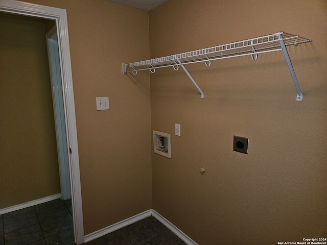 clothes washing area with dark tile patterned floors, hookup for an electric dryer, gas dryer hookup, and washer hookup