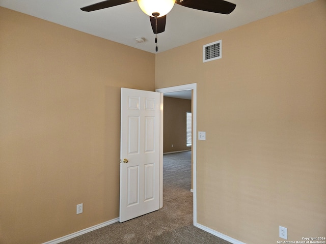 carpeted spare room featuring ceiling fan