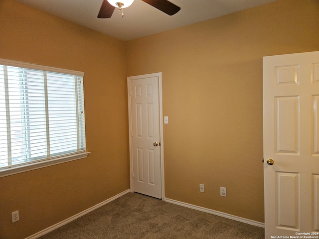 carpeted empty room featuring ceiling fan