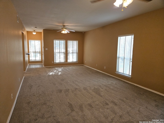 carpeted spare room featuring ceiling fan