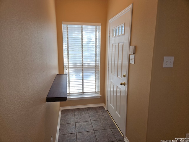 doorway to outside featuring dark tile patterned flooring