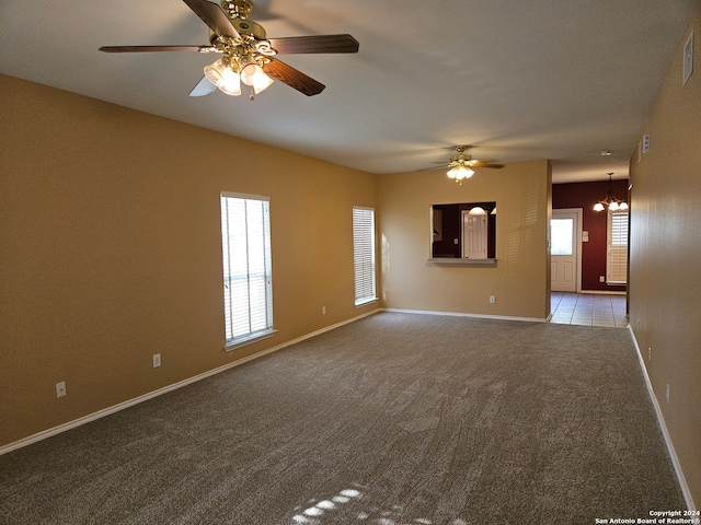 spare room with light colored carpet and ceiling fan with notable chandelier