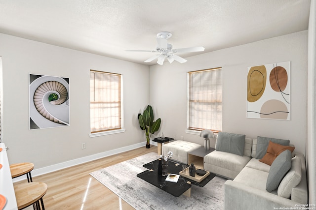 living room with hardwood / wood-style floors, ceiling fan, and a textured ceiling