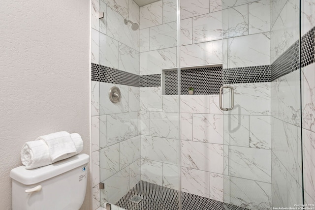 bathroom with toilet and a shower with shower door