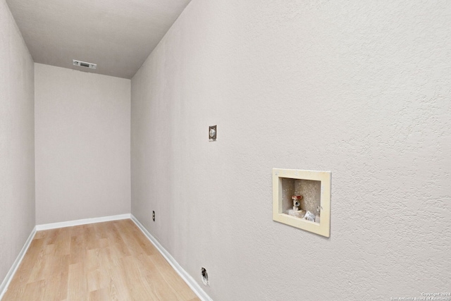 laundry area with hookup for an electric dryer, light hardwood / wood-style floors, and washer hookup