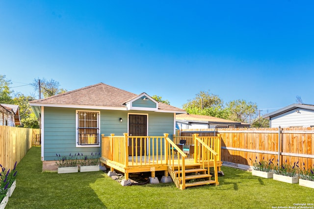 rear view of house featuring a yard and a deck