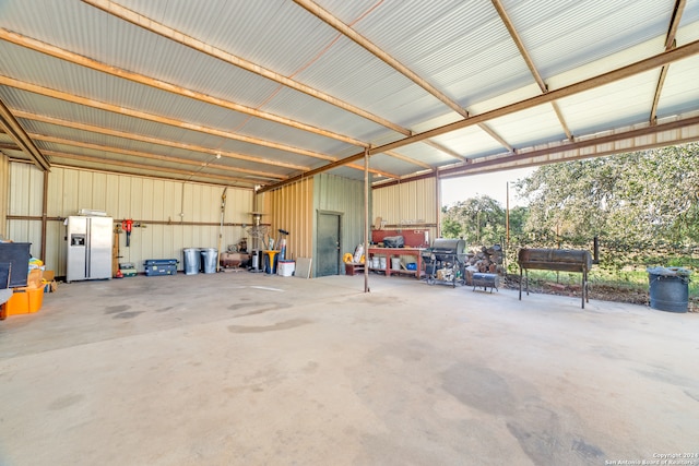 garage featuring white refrigerator with ice dispenser