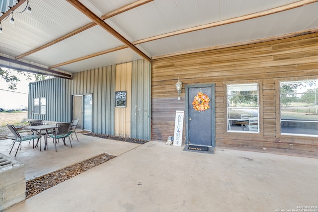 view of exterior entry with a patio area