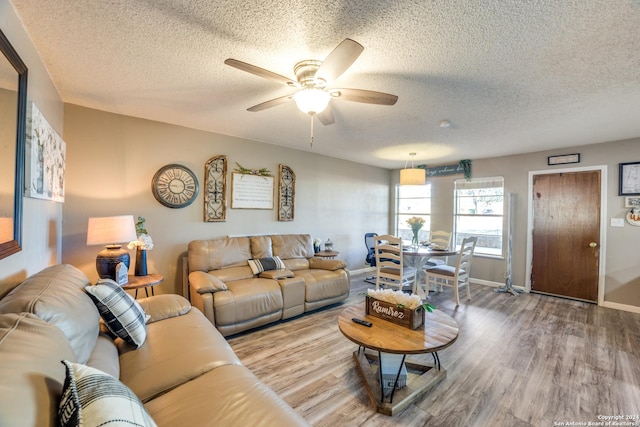 150 S Fisher Ln, Poteet, TX 78065 - living room with ceiling fan, baseboards, wood finished floors, and a textured ceiling