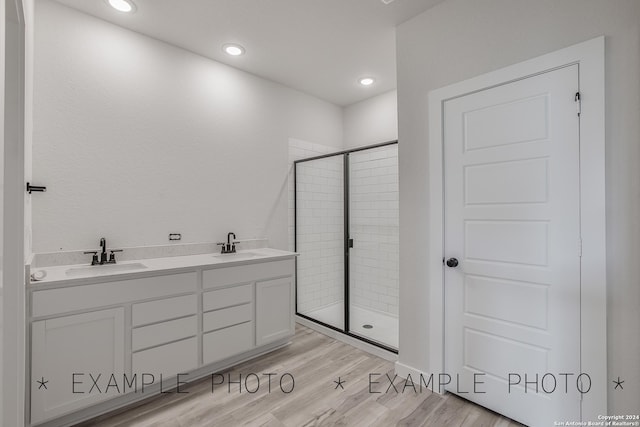 bathroom featuring hardwood / wood-style floors, vanity, and an enclosed shower