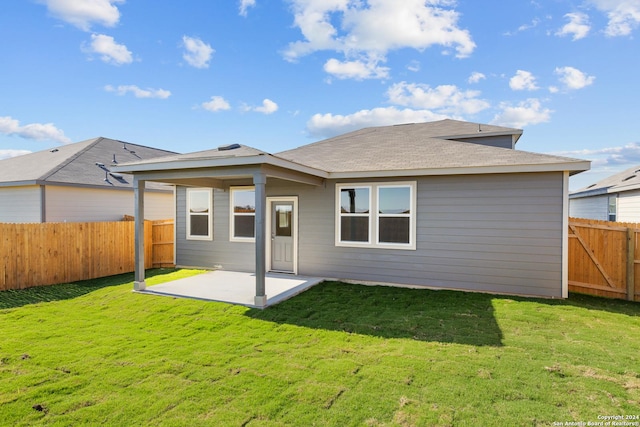 rear view of property featuring a lawn and a patio