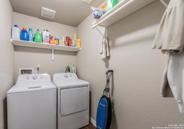 washroom featuring a textured ceiling and separate washer and dryer