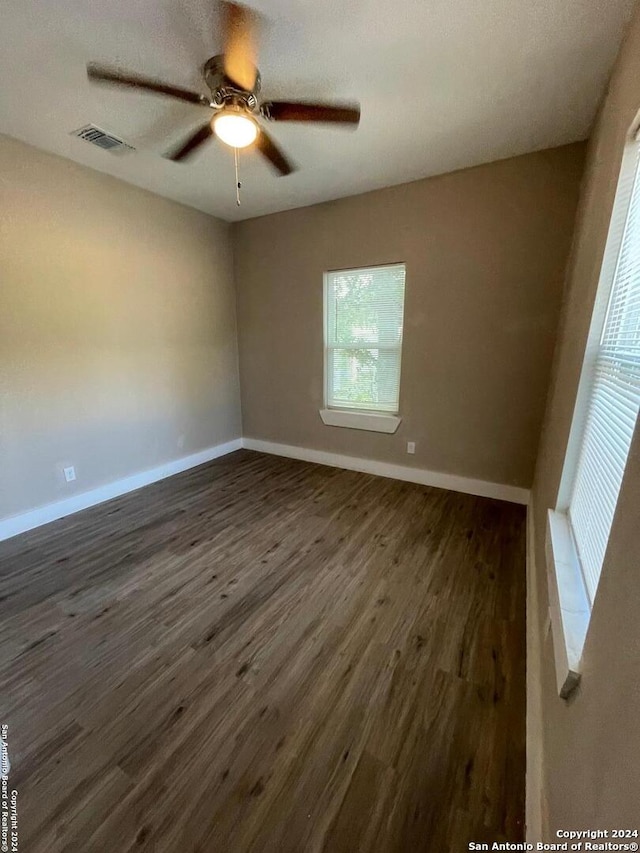 spare room with dark wood-type flooring and ceiling fan