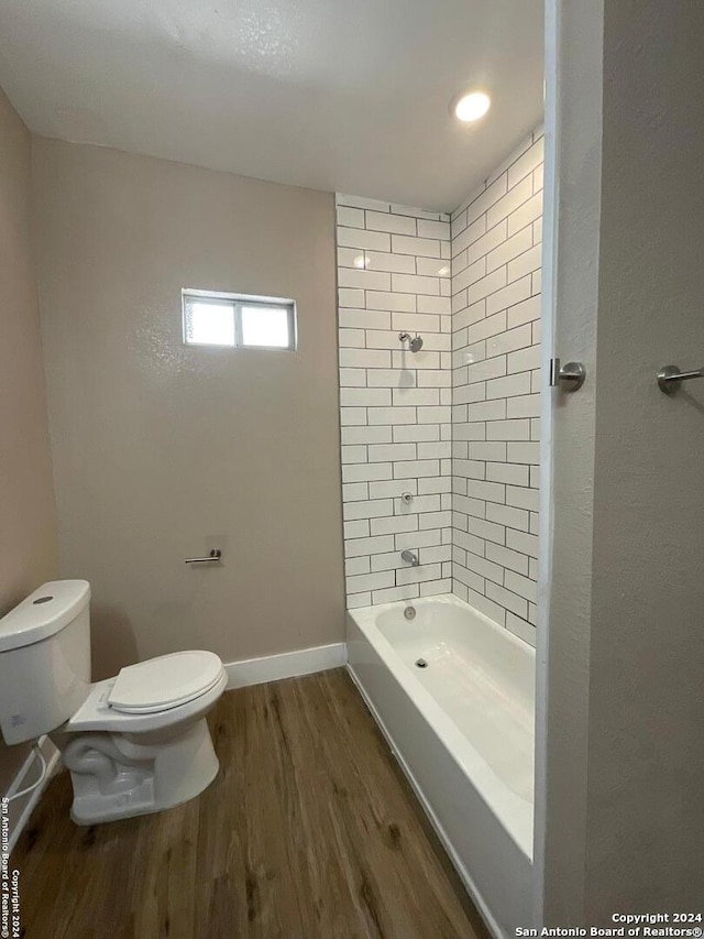 bathroom featuring toilet, tiled shower / bath combo, and hardwood / wood-style flooring