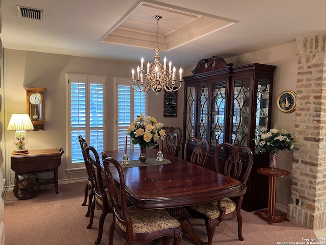 carpeted dining space with a notable chandelier and a tray ceiling