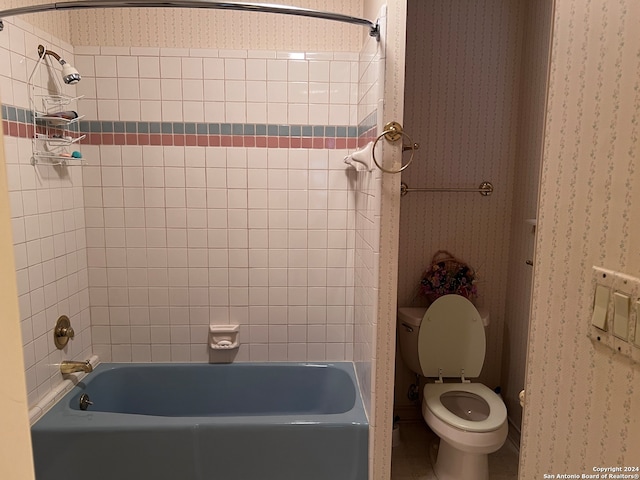 bathroom featuring toilet and tiled shower / bath combo