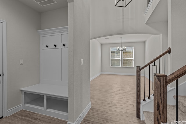 mudroom with an inviting chandelier and light wood-type flooring