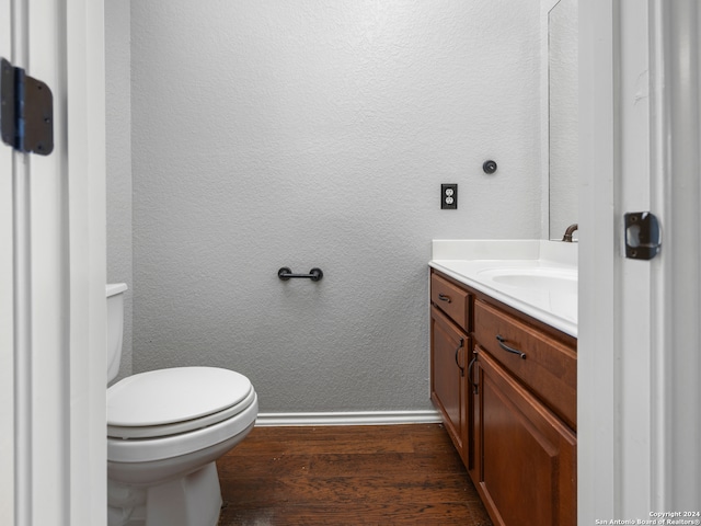 bathroom with toilet, hardwood / wood-style floors, and vanity