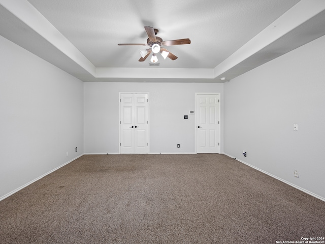 spare room with ceiling fan, carpet flooring, and a raised ceiling