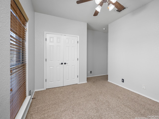 unfurnished bedroom with a closet, ceiling fan, and carpet