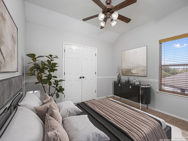 bedroom with a closet, carpet floors, ceiling fan, and vaulted ceiling