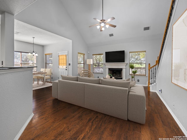 living room featuring a wealth of natural light, ceiling fan with notable chandelier, high vaulted ceiling, and dark hardwood / wood-style flooring