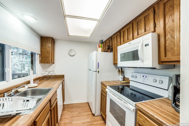 kitchen with light hardwood / wood-style floors, sink, and white appliances