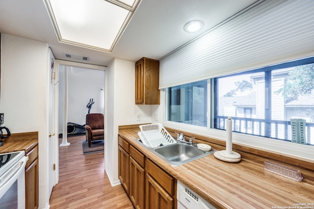 kitchen featuring light hardwood / wood-style floors, sink, and white range with electric stovetop