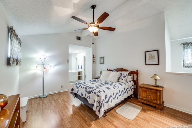 bedroom with lofted ceiling, a textured ceiling, hardwood / wood-style flooring, and ceiling fan