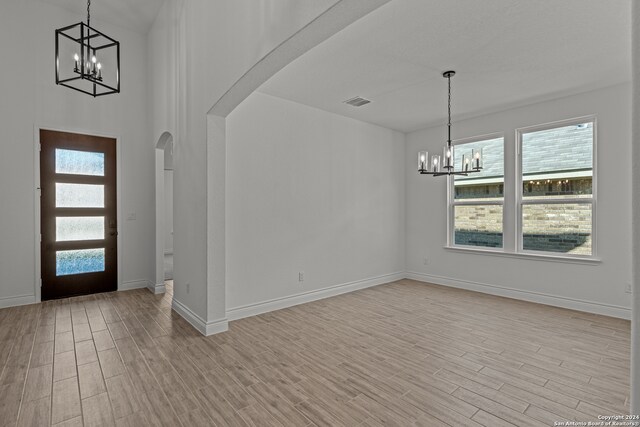 foyer entrance featuring a notable chandelier and light hardwood / wood-style floors