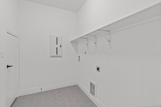 clothes washing area featuring hookup for an electric dryer, hookup for a washing machine, gas dryer hookup, and dark tile patterned flooring