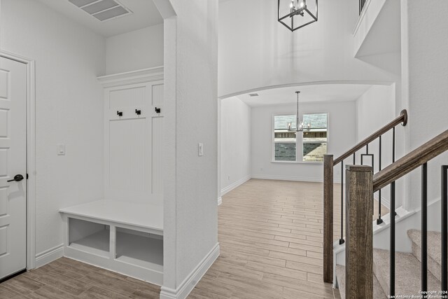 mudroom with a notable chandelier and light hardwood / wood-style floors