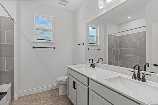 bathroom featuring toilet, hardwood / wood-style flooring, and vanity