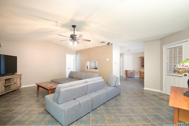 tiled living room featuring ceiling fan and vaulted ceiling