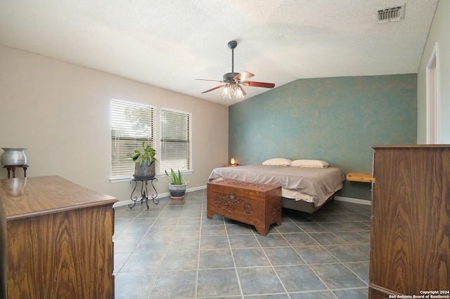 tiled bedroom featuring lofted ceiling, a textured ceiling, and ceiling fan