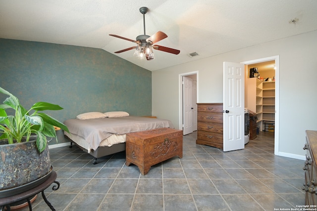 bedroom with a walk in closet, dark tile patterned floors, a closet, ceiling fan, and lofted ceiling