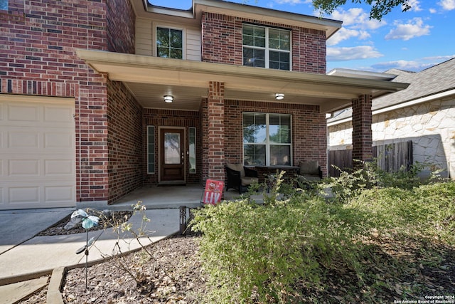 14519 Redwood Vly, San Antonio, TX 78023 - property entrance with covered porch, brick siding, a garage, and fence