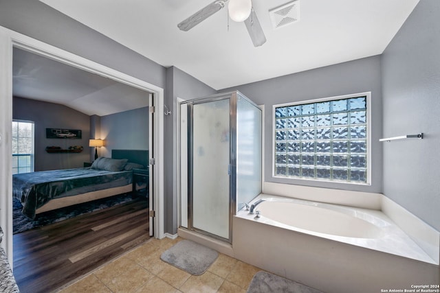 bathroom featuring a healthy amount of sunlight, lofted ceiling, and separate shower and tub