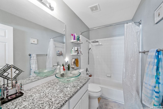 full bathroom with vanity, shower / bath combo, and toilet