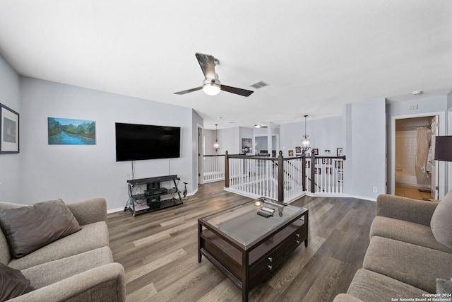 living room with hardwood / wood-style flooring and ceiling fan with notable chandelier