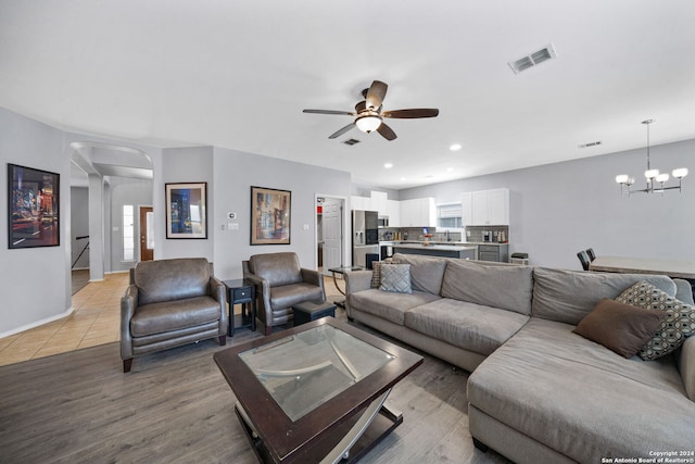 14519 Redwood Vly, San Antonio, TX 78023 - living room with baseboards, ceiling fan with notable chandelier, arched walkways, and visible vents