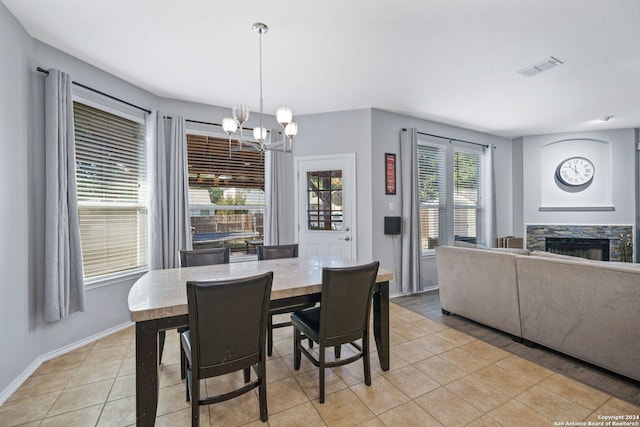 14519 Redwood Vly, San Antonio, TX 78023 - dining area featuring a fireplace, visible vents, baseboards, a chandelier, and light tile patterned flooring