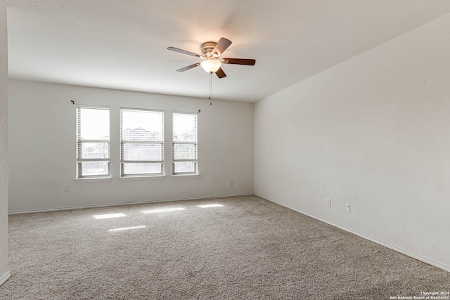 empty room featuring ceiling fan and carpet