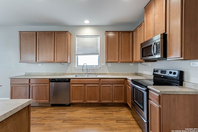 kitchen with light hardwood / wood-style flooring, stainless steel appliances, and sink